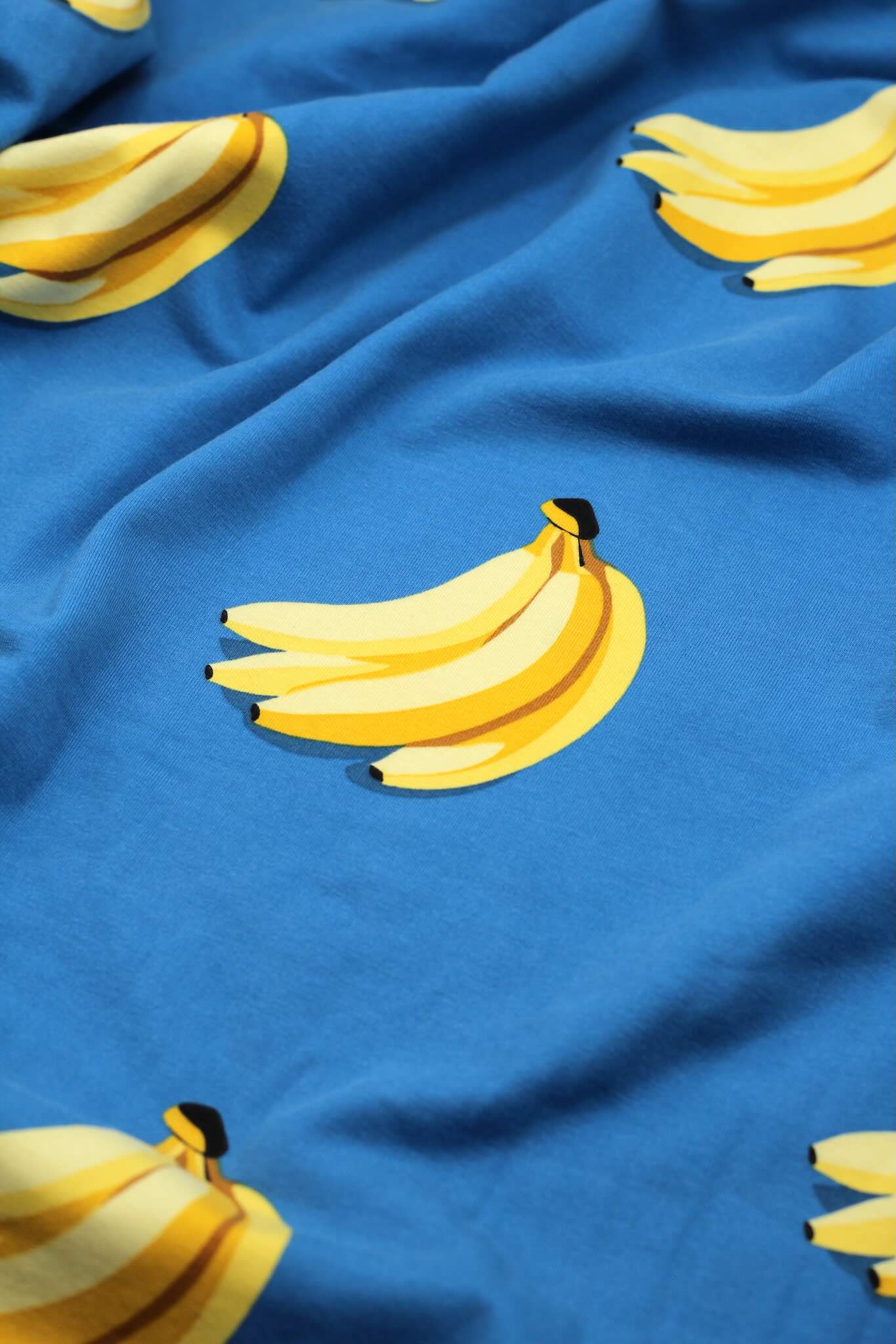 French-Terry-Stoff mit Banenen auf blauen Hintergrund